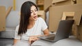 Young caucasian woman using laptop sitting on floor at new home Royalty Free Stock Photo