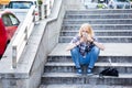 Young Caucasian woman using smart phone while sitting on stairs Royalty Free Stock Photo