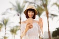Young caucasian woman using smartphone on a beautiful tropical view at luxury hotel. Royalty Free Stock Photo