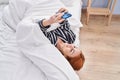 Young caucasian woman using smartphone lying on bed at bedroom Royalty Free Stock Photo