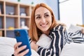 Young caucasian woman using smartphone lying on bed at bedroom Royalty Free Stock Photo