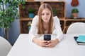 Young caucasian woman using smartphone with serious expression at home Royalty Free Stock Photo
