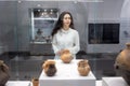 Young caucasian woman visiting museum and looking at ancient clay pot. Concept of cultural education exihibition and