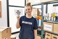 Young caucasian woman volunteer holding we need you banner looking positive and happy standing and smiling with a confident smile Royalty Free Stock Photo