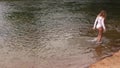 Young Caucasian woman walking in river white leotards