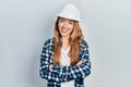 Young caucasian woman wearing architect hardhat happy face smiling with crossed arms looking at the camera Royalty Free Stock Photo