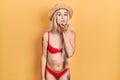 Young caucasian woman wearing bikini and summer hat looking at the camera blowing a kiss with hand on air being lovely and sexy Royalty Free Stock Photo