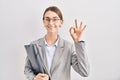 Young caucasian woman wearing business clothes and glasses smiling positive doing ok sign with hand and fingers Royalty Free Stock Photo