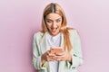 Young caucasian woman wearing business clothes using smartphone celebrating crazy and amazed for success with open eyes screaming Royalty Free Stock Photo