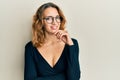 Young caucasian woman wearing business shirt and glasses looking confident at the camera with smile with crossed arms and hand Royalty Free Stock Photo