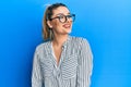 Young caucasian woman wearing business shirt and glasses looking to side, relax profile pose with natural face and confident smile Royalty Free Stock Photo