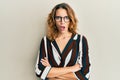 Young caucasian woman wearing business shirt and glasses in shock face, looking skeptical and sarcastic, surprised with open mouth Royalty Free Stock Photo