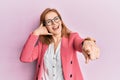 Young caucasian woman wearing business style and glasses smiling doing talking on the telephone gesture and pointing to you Royalty Free Stock Photo