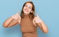 Young caucasian woman wearing casual clothes approving doing positive gesture with hand, thumbs up smiling and happy for success Royalty Free Stock Photo