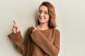 Young caucasian woman wearing casual clothes and glasses smiling and looking at the camera pointing with two hands and fingers to Royalty Free Stock Photo