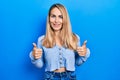 Young caucasian woman wearing casual clothes success sign doing positive gesture with hand, thumbs up smiling and happy Royalty Free Stock Photo