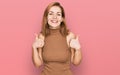 Young caucasian woman wearing casual clothes success sign doing positive gesture with hand, thumbs up smiling and happy Royalty Free Stock Photo