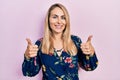 Young caucasian woman wearing casual clothes success sign doing positive gesture with hand, thumbs up smiling and happy Royalty Free Stock Photo