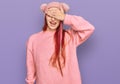 Young caucasian woman wearing casual clothes and wool cap smiling and laughing with hand on face covering eyes for surprise Royalty Free Stock Photo