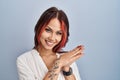 Young caucasian woman wearing casual white shirt over isolated background clapping and applauding happy and joyful, smiling proud Royalty Free Stock Photo