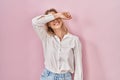 Young caucasian woman wearing casual white shirt over pink background covering eyes with arm smiling cheerful and funny Royalty Free Stock Photo