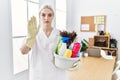 Young caucasian woman wearing cleaner uniform holding cleaning products cleaning office with open hand doing stop sign with Royalty Free Stock Photo