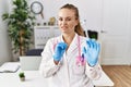 Young caucasian woman wearing doctor uniform and stethoscope at the clinic disgusted expression, displeased and fearful doing