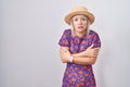 Young caucasian woman wearing flowers dress and summer hat shaking and freezing for winter cold with sad and shock expression on Royalty Free Stock Photo