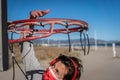 Young Caucasian woman wearing a mask with headphones and phone dunking on basketball ring