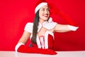 Young caucasian woman wearing santa claus costume very happy and smiling looking far away with hand over head Royalty Free Stock Photo