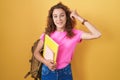 Young caucasian woman wearing student backpack and holding books smiling pointing to head with one finger, great idea or thought, Royalty Free Stock Photo