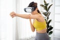 Young caucasian woman wearing vr headset while workout and exercise together at living room.