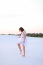 Young caucasian woman wearing white dress walking barefoot on sa Royalty Free Stock Photo