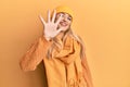 Young caucasian woman wearing wool winter sweater and cap showing and pointing up with fingers number five while smiling confident