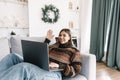 Young caucasian woman wishes merry christmas by video call using laptop computer in holidays at home on the sofa Royalty Free Stock Photo