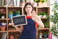 Young caucasian woman working at florist holding open sign with open hand doing stop sign with serious and confident expression,