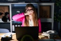 Young caucasian woman working at the office at night smiling and laughing with hand on face covering eyes for surprise Royalty Free Stock Photo