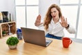Young caucasian woman working at the office using computer laptop doing stop gesture with hands palms, angry and frustration Royalty Free Stock Photo