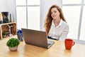 Young caucasian woman working at the office using computer laptop looking sleepy and tired, exhausted for fatigue and hangover, Royalty Free Stock Photo