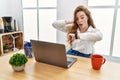 Young caucasian woman working at the office using computer laptop looking at the watch time worried, afraid of getting late Royalty Free Stock Photo