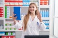 Young caucasian woman working at pharmacy drugstore doing video call with tablet looking positive and happy standing and smiling Royalty Free Stock Photo