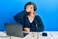 Young caucasian woman working at radio studio peeking in shock covering face and eyes with hand, looking through fingers afraid Royalty Free Stock Photo