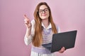 Young caucasian woman working using computer laptop gesturing finger crossed smiling with hope and eyes closed