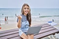 Young caucasian woman working using computer laptop outdoors pointing thumb up to the side smiling happy with open mouth Royalty Free Stock Photo