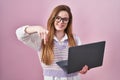 Young caucasian woman working using computer laptop pointing to you and the camera with fingers, smiling positive and cheerful Royalty Free Stock Photo