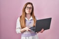 Young caucasian woman working using computer laptop puffing cheeks with funny face Royalty Free Stock Photo