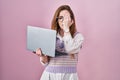 Young caucasian woman working using computer laptop yawning tired covering half face, eye and mouth with hand Royalty Free Stock Photo