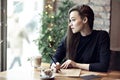 Young caucasian woman working, writing in a restaurant. Business concept. Stationary layouts