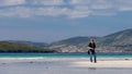 Young Caucassian woman enjoying holiday on a white sandy beach with turquoise water