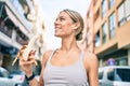 Young cauciasian fitness woman wearing sport clothes training outdoors eating healthy banana for strength and energy